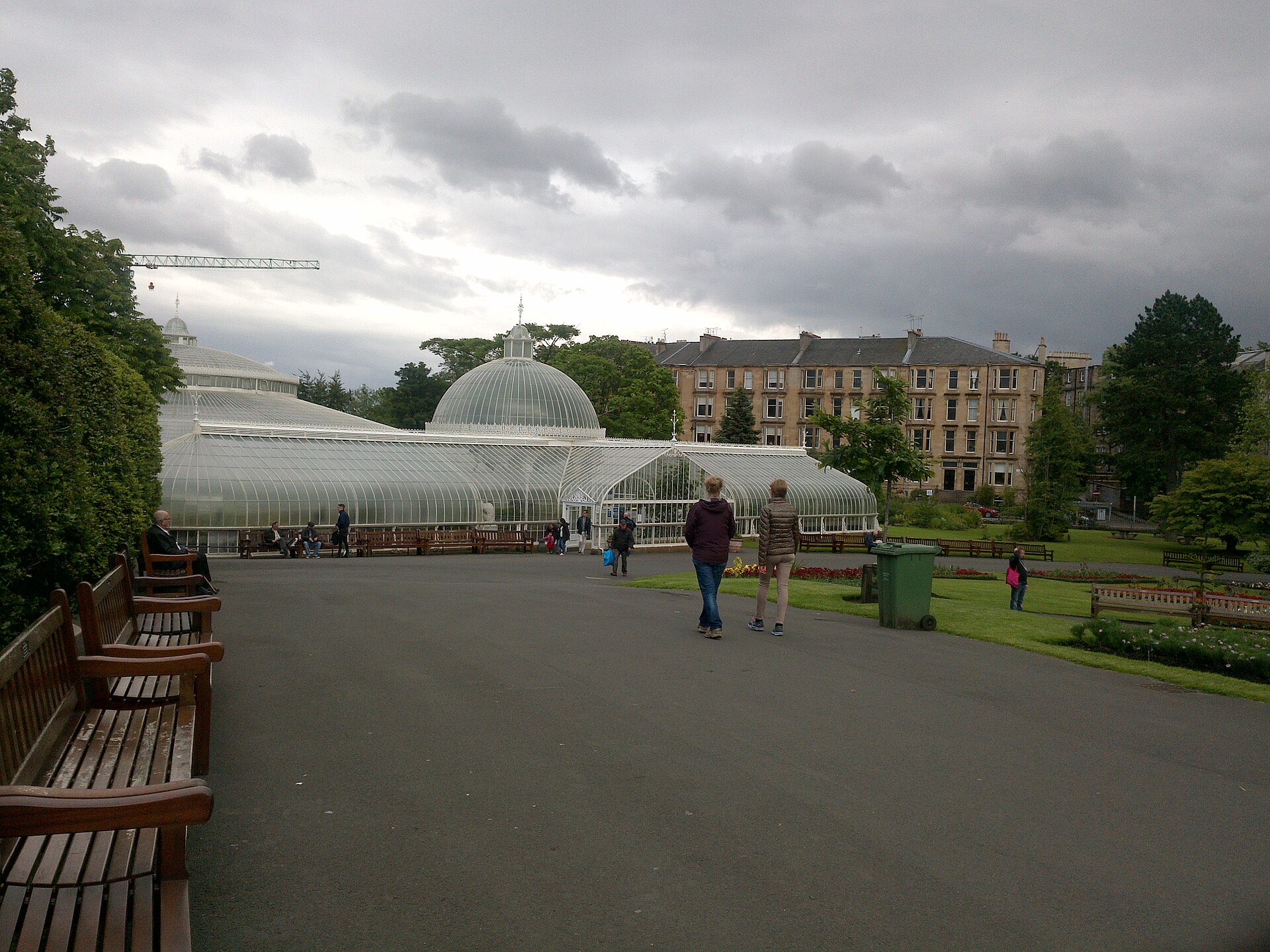 People strolling past the Kibble Palace glasshouse in Glasgow's Botanic Gardens